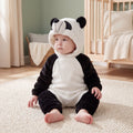 Select Panda one-piece on child in a sage nursery, three-quarter view, attached panda hood and open ankle cuffs.