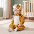 Select Tiger one-piece on child in a sage nursery, three-quarter view, attached tiger hood and pale lower-foot sections.
