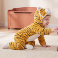 Select Tiger one-piece on child in playful side view on an oat rug, attached tiger hood and pale lower-foot sections.